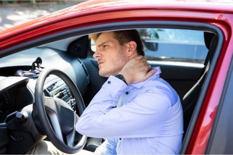 Whiplash, man holding neck in car